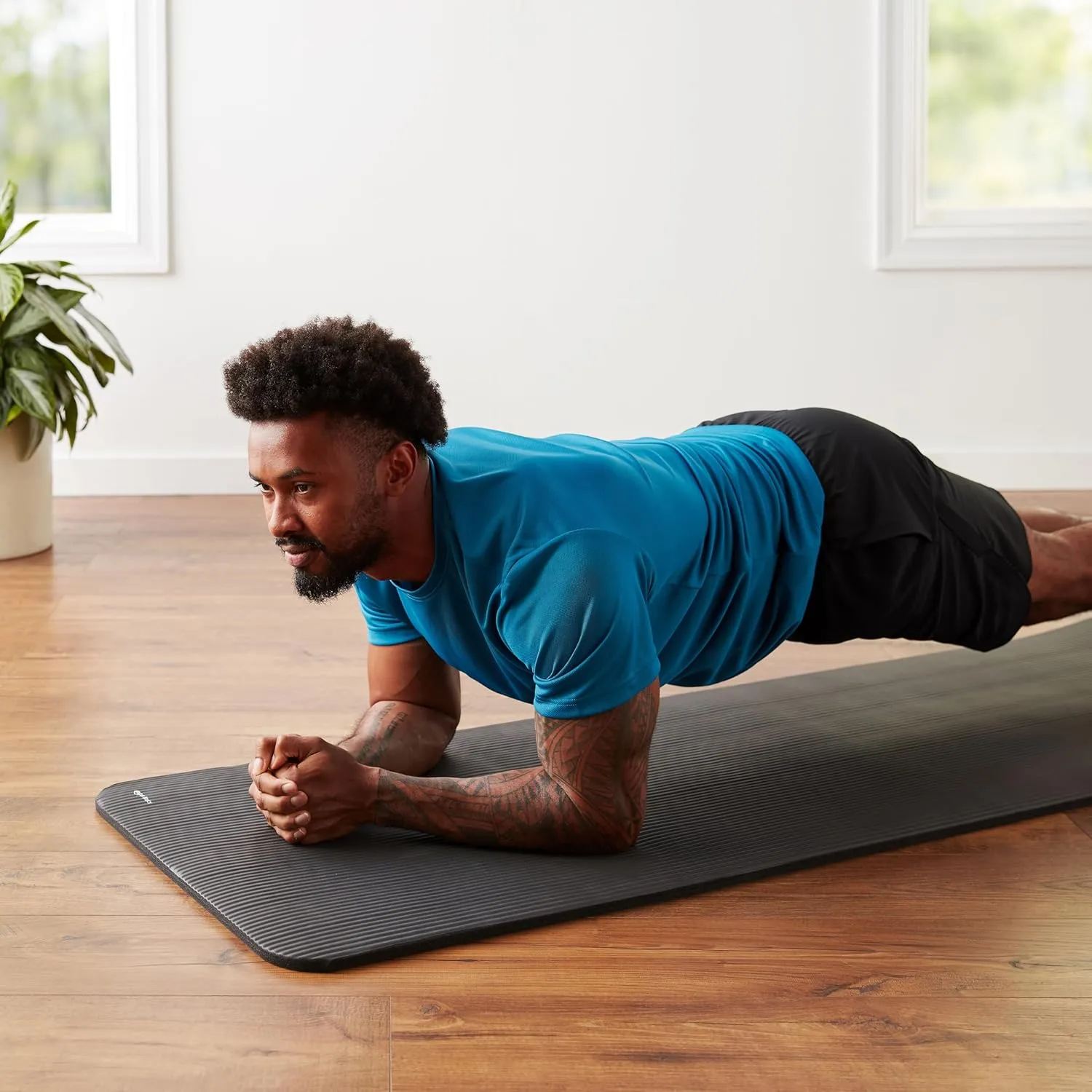 Packaged rolled Amazon Basics exercise mat with strap included.
